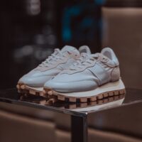 Elegant white sneakers displayed on a reflective surface, perfect for fashion-forward looks.